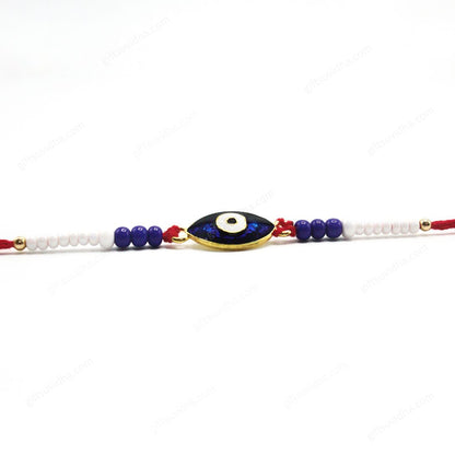 Oval Evil Eye Rakhi blending traditional symbolism with modern elegance, featuring a reflective blue resin eye, red threads, and vibrant blue and white beads.